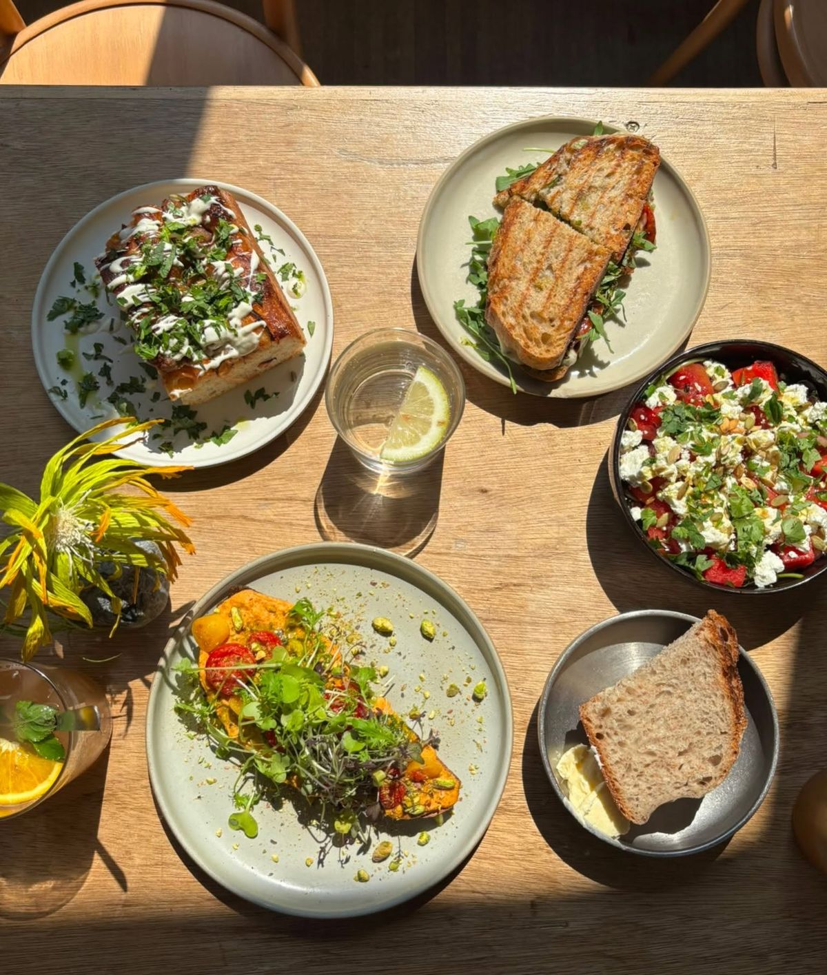 Zonnig terrastafeltje met broodjes, salade en verse jus